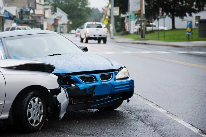 Carolina Collision and Frame Service | A gray car and a blue car on the side of the road with damage after a wreck