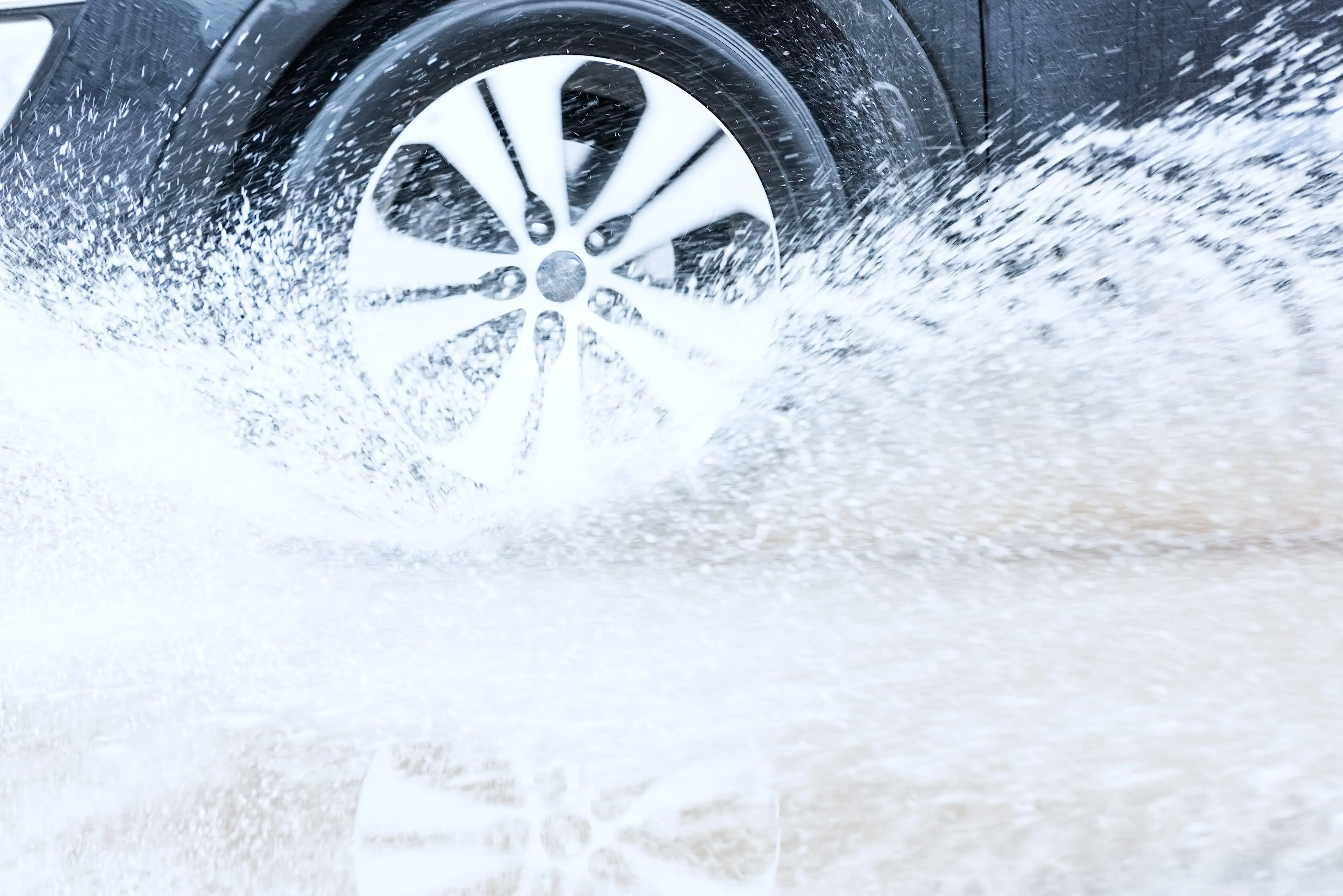 Carolina Collision and Frame Service | Black car's tire spinning in water and splashing
